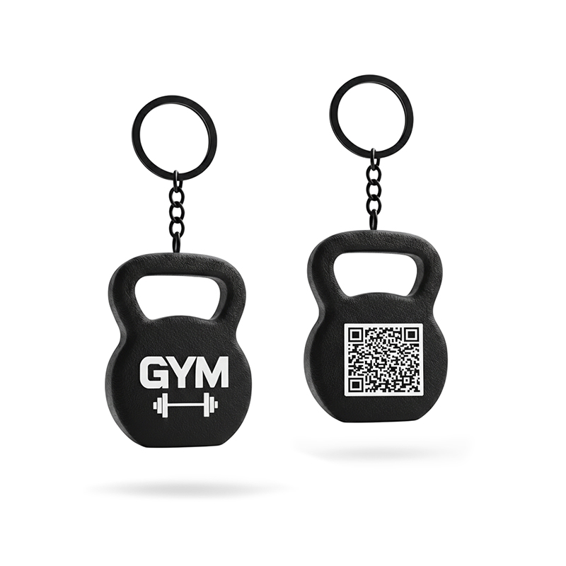 A 3D kettlebell-shaped keychain in black and white, featuring a raised texture and a QR code on the front, manufactured by the Polish producer DECARD