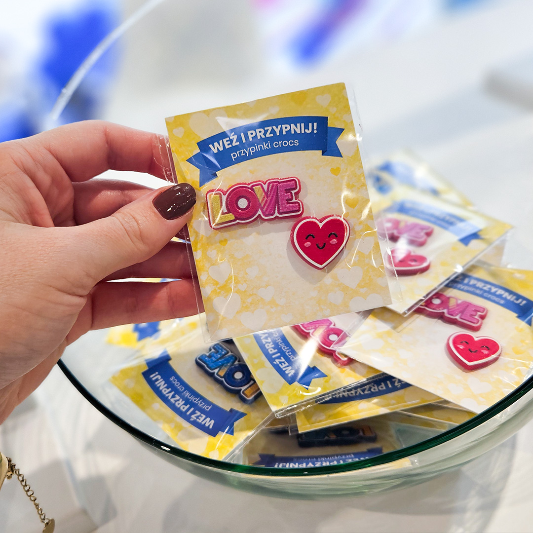 Colorful Crocs charms in the shape of hearts and the word LOVE, made from raised resin, packed in dedicated boxes and presented in a glass bowl. Manufactured in Poland by DECARD