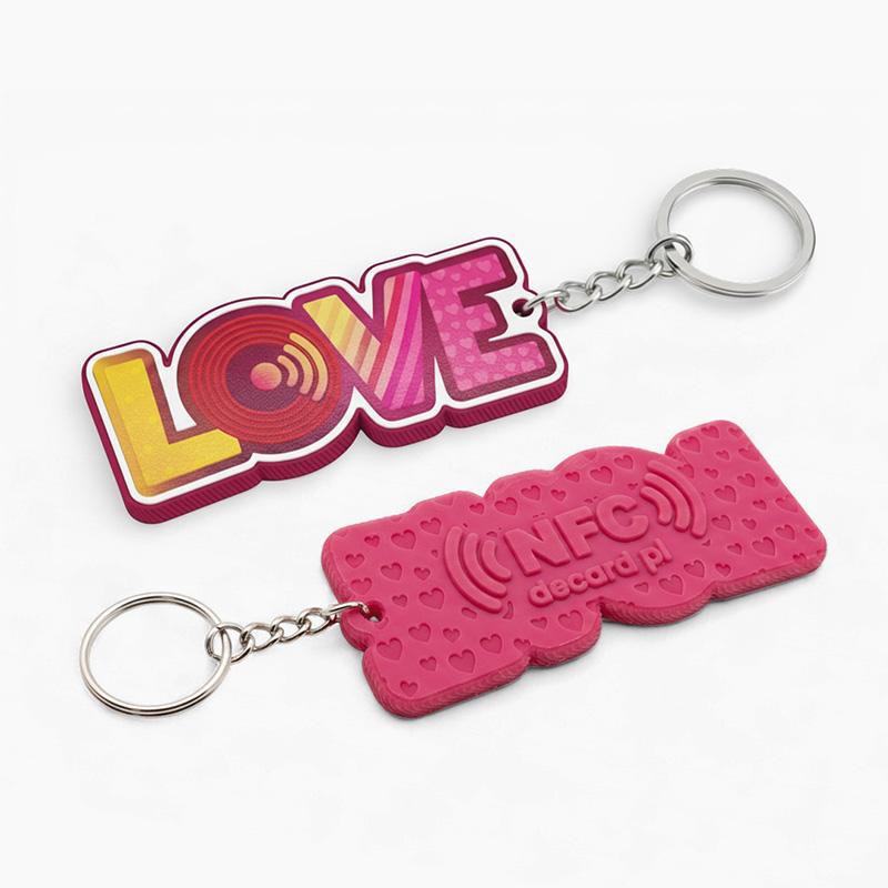Pink LOVE letter keychain, raised texture on the front with stripes, patterns and dots; 3D marking on the back – NFC text, website address and recessed hearts, made by Polish manufacturer DECARD