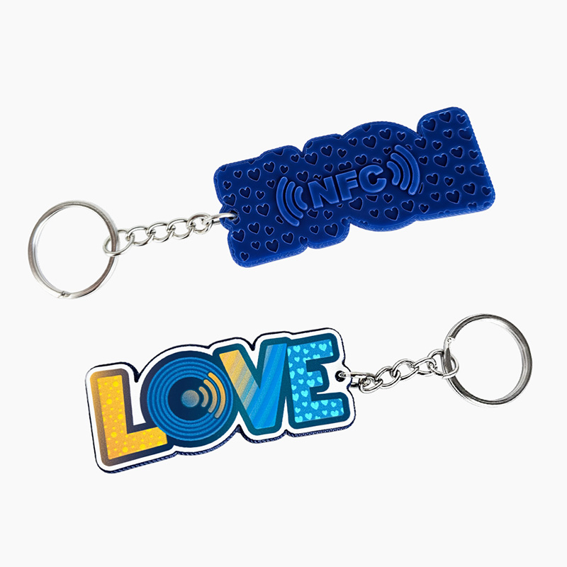 Blue LOVE letter keychain, raised texture on the front with stripes, patterns and dots; 3D marking on the back – NFC text and recessed hearts, made by Polish manufacturer DECARD