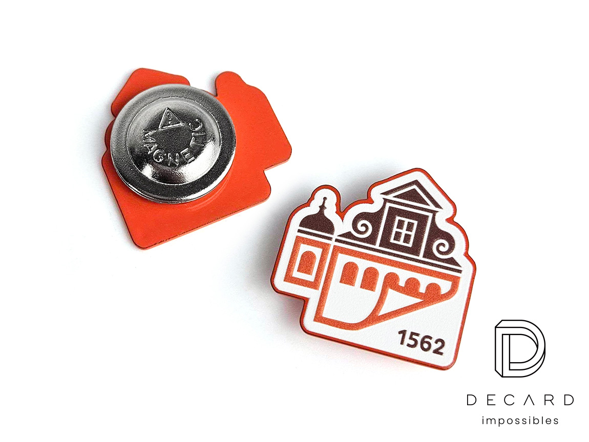 Metal pin – front and back view; city print on the front, magnetic clasp on the back; made by Polish manufacturer DECARD