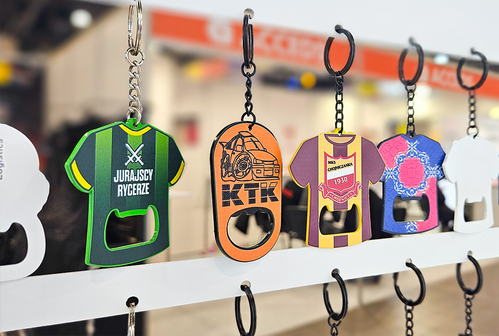 Keychains with bottle opener function – metal, sports jerseys with crests – hanging at the DECARD booth during PROMO SHOW 2026
