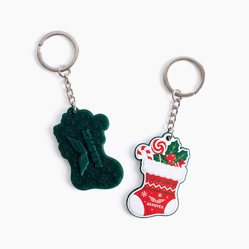 Christmas stocking keychains, featuring colorful graphics on the front and a raised logo on the back, made in Poland by DECARD