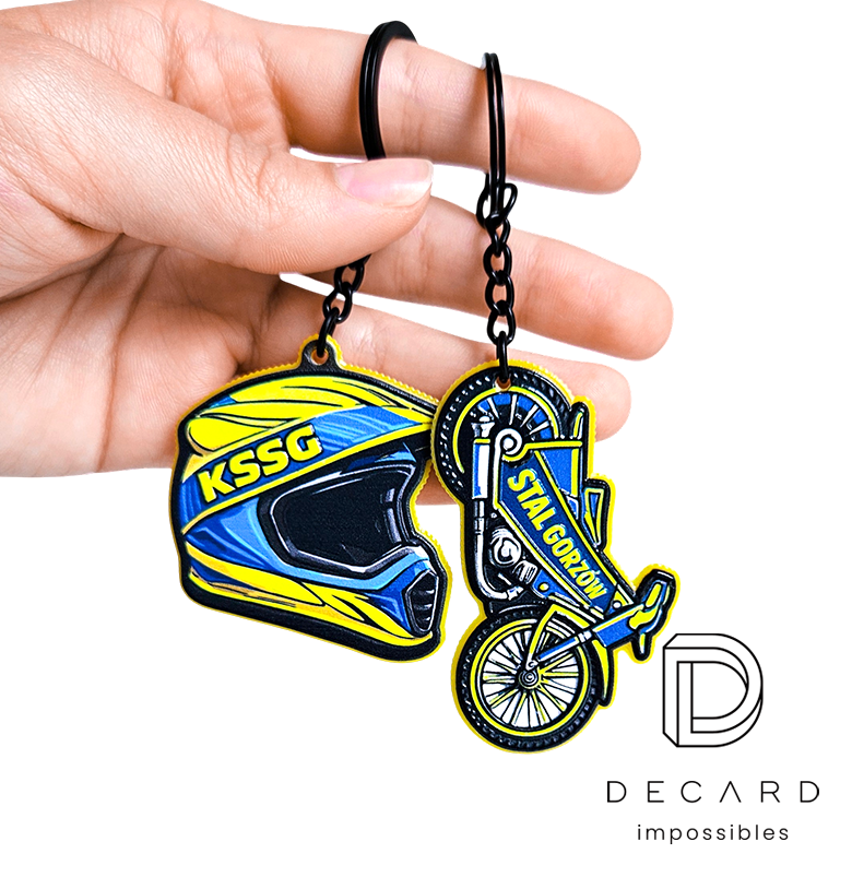 Speedway motorcycle and helmet keychains held in a hand, Stal Gorzów, made by Polish manufacturer DECARD