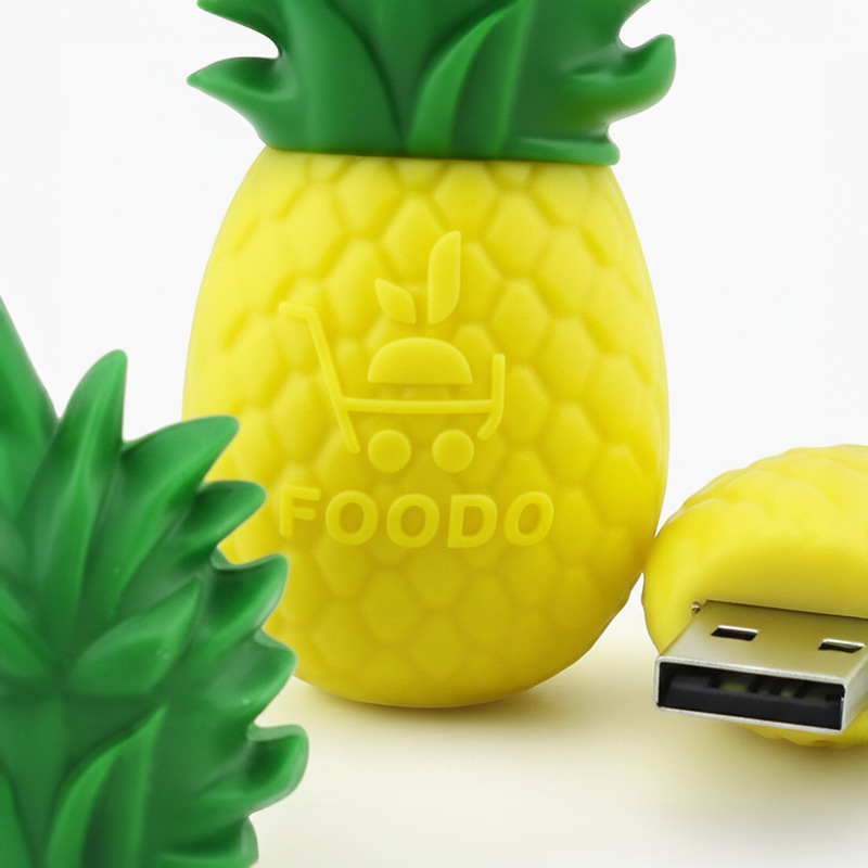 Zbliżenie na logo FOODO w 3D na brzegach pendrive’a w kształcie ananasa, widoczna realistyczna tekstura owocu i liście zatyczki. Projekt polskiego producenta DECARD