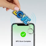 Brelok napis Love, z tagiem NFC przyłożony do telefonu, wykonanie polski producent DECARD