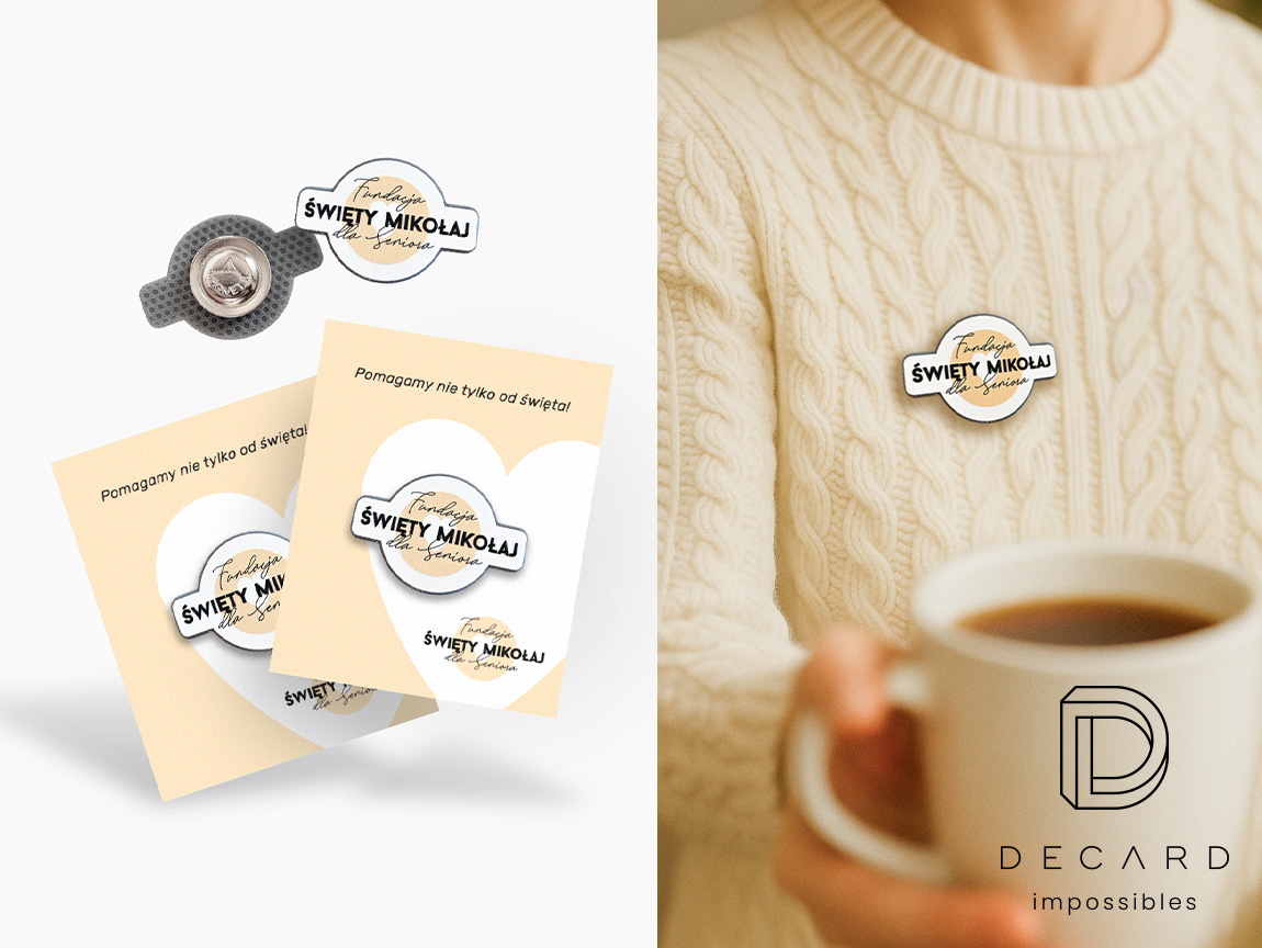Eleganckie przypinki z logo Fundacji Święty Mikołaj dla seniora, na swetrze i dedykowanym kartoniku, wykonanie polski producent DECARD
